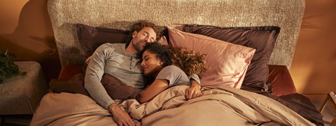 Een man en vrouw liggen in bed