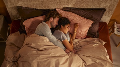 Een man en een vrouw die in bed slapen