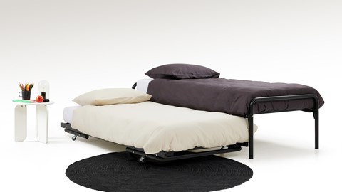 een bed met een zwarte mat op de vloer