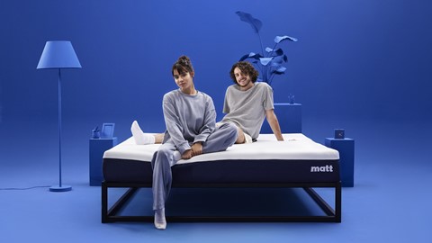 Een man en een vrouw die op een matras zitten