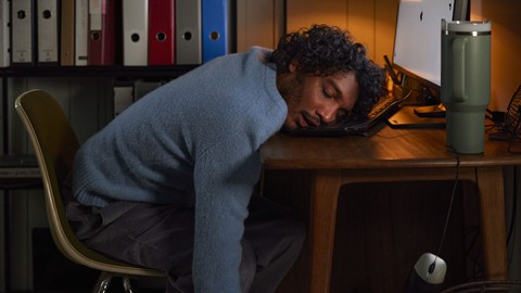 Een man die op een laptop slaapt