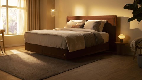 Een bed met een houten hoofdeinde