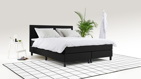 een bed met witte lakens en kussens