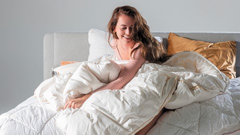 Een vrouw die in een bed ligt