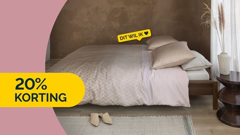 Een bed met kussens en schoenen op de vloer