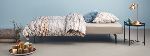 een bed met een kussen en deken