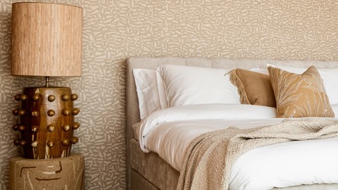 een bed met kussens en een lamp