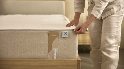 een persoon die een matras vasthoudt