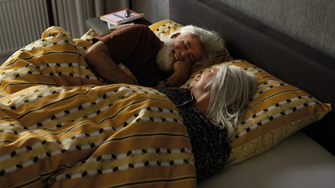 Een man en een vrouw die in bed liggen