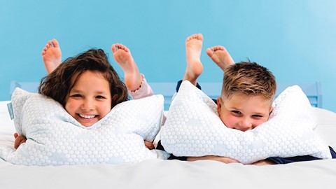 Een paar kinderen die op een bed liggen