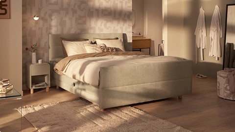 een bed met kussens en een tapijt in een kamer