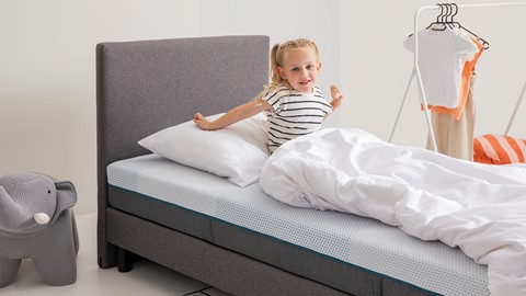 Een meisje dat op een bed ligt