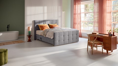 een bed in een kamer met een tafel en stoelen