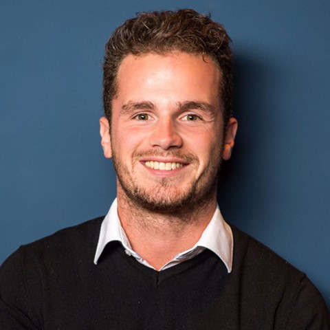 Een man die naar de camera lacht