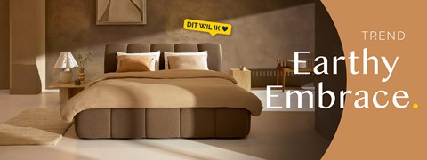 een bed met een stoel en een tafel in een kamer