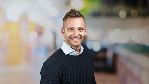 Een man die naar de camera lacht