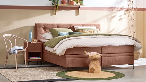 een bed met een roze bedframe