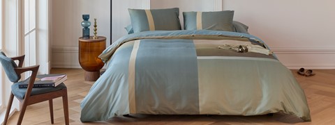 een bed met een laken en kussens