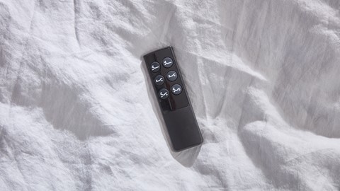 een afstandsbediening op een witte deken