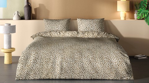 een bed met kussens en een sprei
