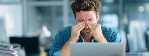 een man die zijn ogen vasthoudt met zijn handen