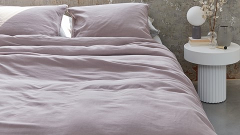 een bed met een witte lamp ernaast