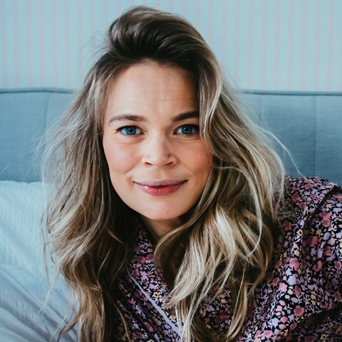 Een vrouw die bij camera glimlacht
