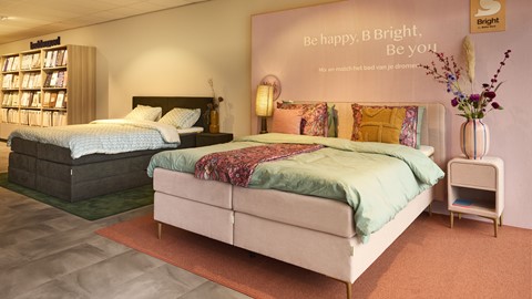 een bed met kussens en een lamp aan de zijkant