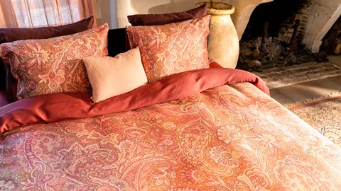 een bed met kussens en een open haard
