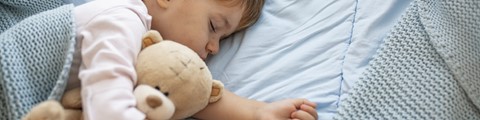Een kind dat met een knuffel slaapt