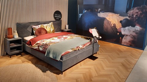 een bed met een poster aan de muur