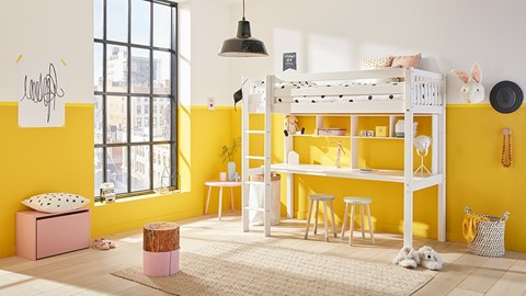 een kamer met een stapelbed en een gele muur