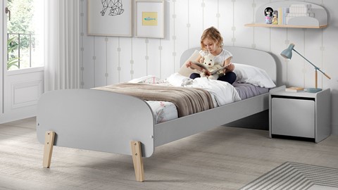 Een meisje dat een boek op een bed leest