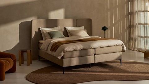 Een bed met een lamp op een tapijt