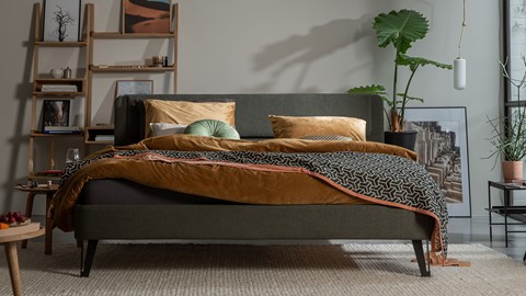 een bed met een groene plant op de achtergrond
