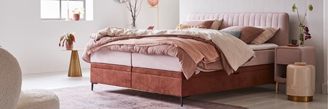 een bed met roze en witte lakens