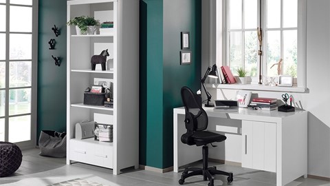 een bureau in een kamer met een witte boekenkast en een zwarte stoel