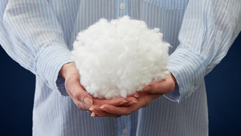 een persoon die een pluizig wit voorwerp vasthoudt