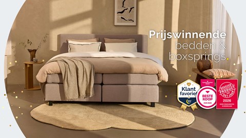 Een bed met kussens en dekens in een kamer
