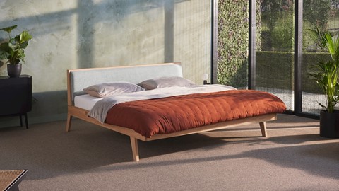 een bed met een rode deken en kussens