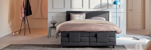 een bed met een roze kussen