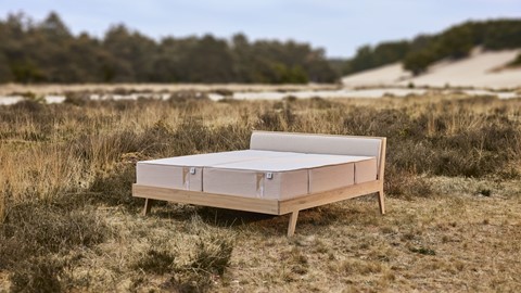 Excellence matras op eenvoudig houten bed in duinlandschap