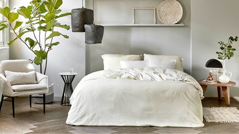 een bed met witte lakens en kussens