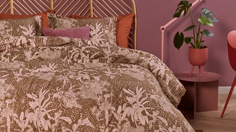 een bed met een plant op de achtergrond