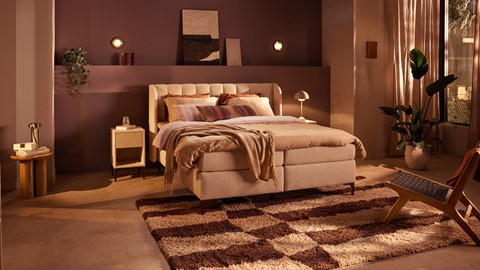 een bed met een kleed en lampen