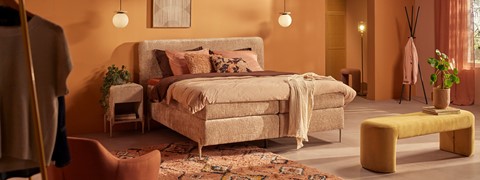 een bed met kussens en een kleed in een kamer