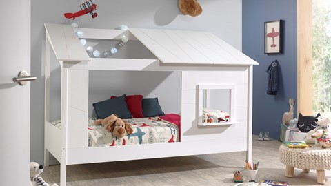 een wit bed met een dak en een hondenspeeltje