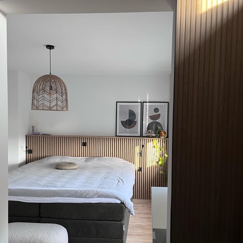 een slaapkamer met een bed en een lamp