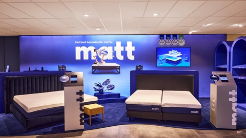 een kamer met matrassen en een uithangbord