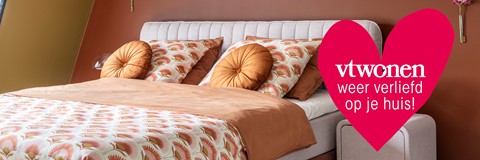 een bed met kussens en een rode lamp